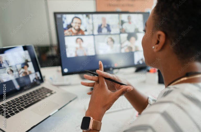 Businesswoman video conferencing at laptop and computer in office