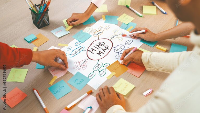 Professional startup group share creative marketing idea by using mind map. Young skilled business people brainstorm business plan while writing sticky notes. Focus on hand. Closeup. Variegated.